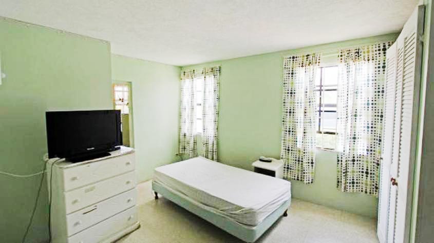 Bedroom off of Kitchen or Foyer by wooden stairs ground floor